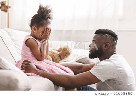 African father scolding little girl at home 61658360