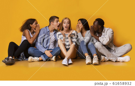 Shocked girl listening to her classmates whispers Shocked girl listening to her classmates whispers 61658932