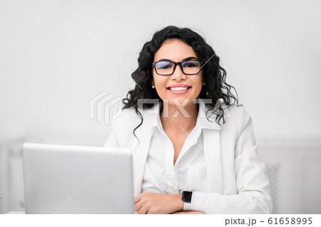 Happy mexican manager smiling at camera in office 61658995