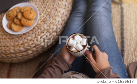 Young woman enjoying hot chocolate with marshmallows Young woman enjoying hot chocolate with marshmallows 61659617