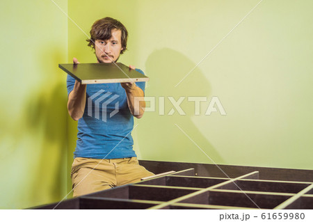 Frustrated Man Putting Together Self Assembly Furniture Frustrated Man Putting Together Self Assembly Furniture 61659980
