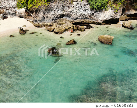 Aerial view of an amazing little beach with rock cliff in Bali. Aerial view of an amazing little beach with rock cliff in Bali. 61660833