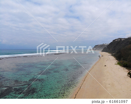 Aerial view of blue transparent ocean over sandy coastline with cliff, Bali 61661097
