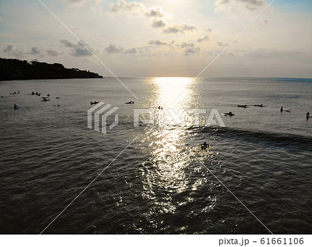Aerial view of surfers on their board waiting the waves during sunset 61661106