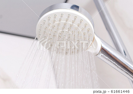 Water jets from white plastic shower head. 61661446