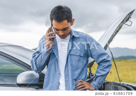 Asian man calling car maintenance service after 61661709