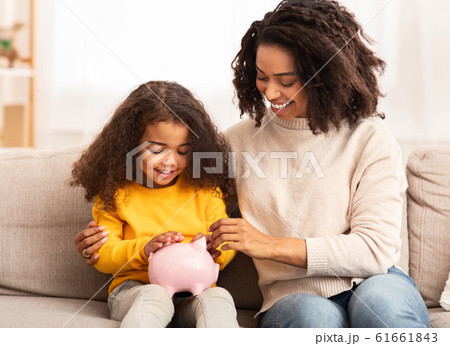 Cheerful Mother Teaching Daughter How To Save Money At Home 61661843
