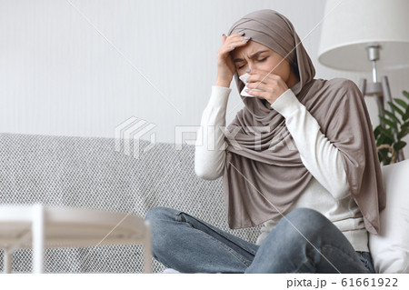 Sick Arabic Woman Suffering From Headache And Runny Nose At Home 61661922