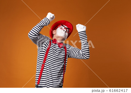 Angry mime in red hat and vest on orange background 61662417