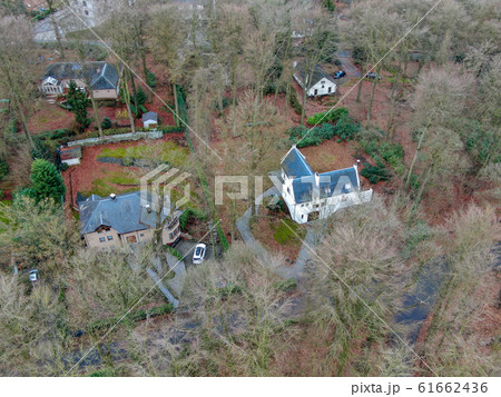 Aerial view of big villas with garden surrounded by forest during winte season 61662436
