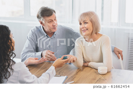 Female doctor giving blue inhaler to senior patient 61662454
