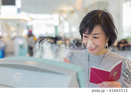初めての搭乗手続き 航空券発券手続きするミドル女性の喜怒哀楽シーン 61663513