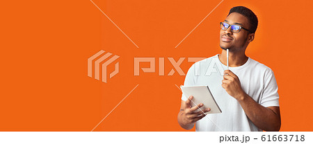 Pensive black guy portrait on orange background Pensive black guy portrait on orange background 61663718