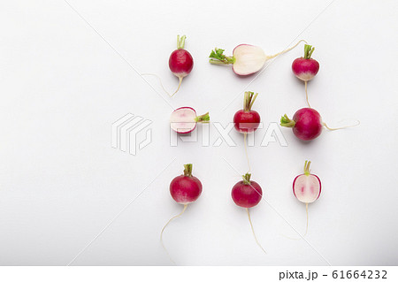 Composition of cut and whole radishes on white background 61664232