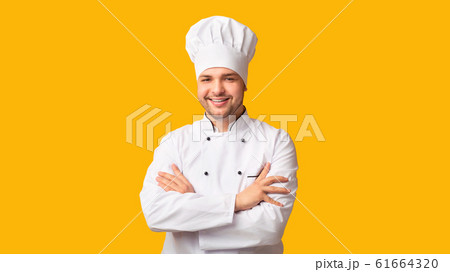 Positive Chef Man Smiling At Camera Crossing Hands, Yellow Background Positive Chef Man Smiling At Camera Crossing Hands, Yellow Background 61664320