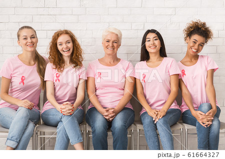 Multiracial Women In Pink Awareness T-Shirts Sitting On Chairs Indoor 61664327