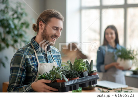 Man wearing an apron taking care of plants 61665523