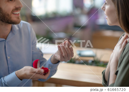 Man pesenting an engagement ring to his girlfriend Man pesenting an engagement ring to his girlfriend 61665720