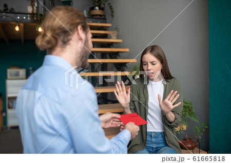 Man giving an envelope to the worried woman Man giving an envelope to the worried woman 61665818