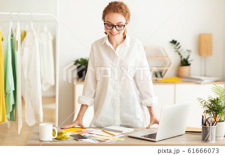 Happy tailor working in own dressmaking studio 61666073