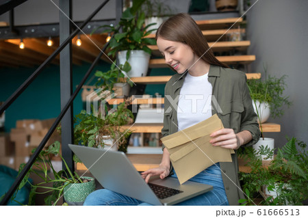 Woman working with a computer and envelopes 61666513