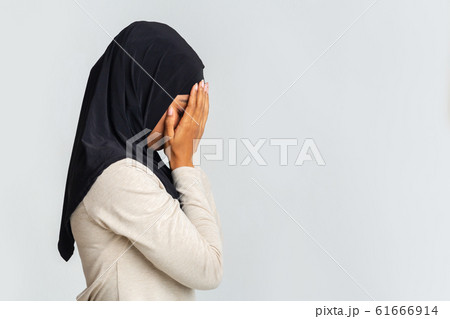 Profile portrait of desperate black muslim woman covering face with hands Profile portrait of desperate black muslim woman covering face with hands 61666914