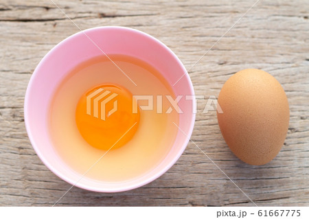 Broken egg shells and raw egg in small bowl  at 61667775