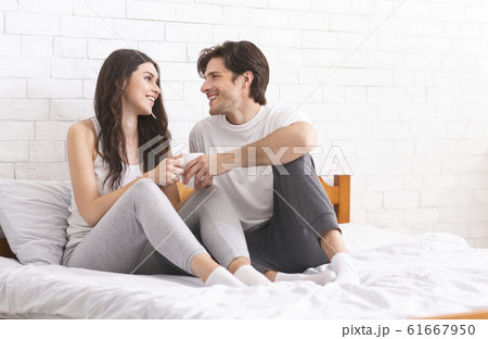 Happy newlyweds enjoying first married morning in bed 61667950