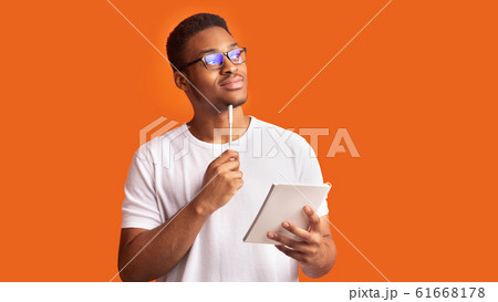Pensive afro man portrait on orange background 61668178