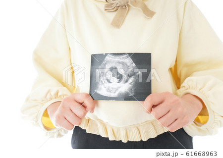 エコー画像を持つ若い妊婦の女性 エコー画像を持つ若い妊婦の女性 61668963