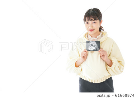 エコー画像を持つ若い妊婦の女性 エコー画像を持つ若い妊婦の女性 61668974