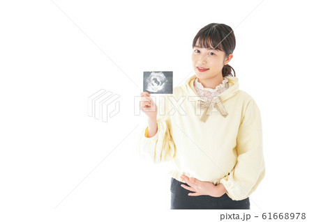 エコー画像を持つ若い妊婦の女性 エコー画像を持つ若い妊婦の女性 61668978