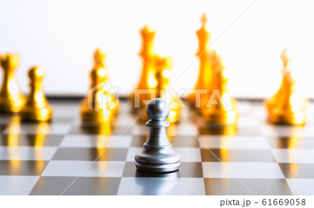 One gold pawn chess piece is standing alone on chessboard One gold pawn chess piece is standing alone on chessboard 61669058