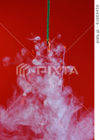 Burning fuse wick cord with sparks and smoke on red background 61669450