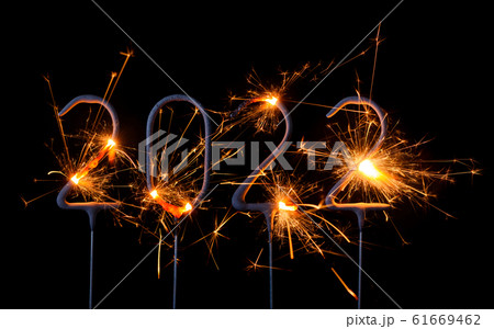 Happy New Year 2022. Digits of year 2022 made by burning sparklers isolated on black background. 61669462
