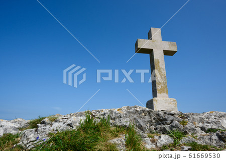 Christian cross on rock over blue sky as copy-space 61669530