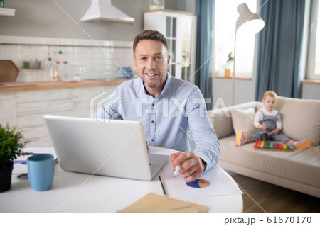 Bearded man in a blue shirt feeling positive 61670170