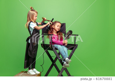 Little girl dreaming about future profession of visage and hairstyle artist Little girl dreaming about future profession of visage and hairstyle artist 61670881