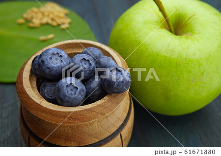 Macro fresh ripe blueberries next to green apple 61671880