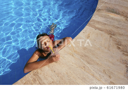 Beautiful boy with relaxing at swimming pool 61671980