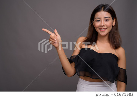 Young beautiful Asian woman against gray background 61671982