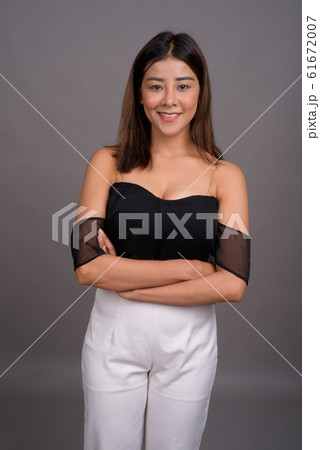 Young beautiful Asian woman against gray background Young beautiful Asian woman against gray background 61672007