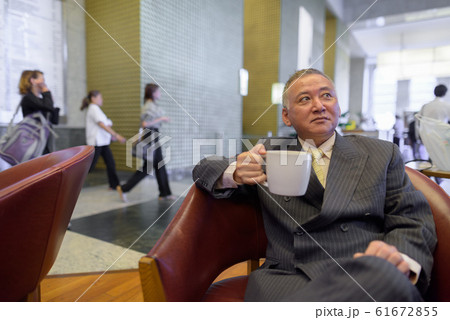 Mature Asian businessman relaxing inside the coffee shop Mature Asian businessman relaxing inside the coffee shop 61672855