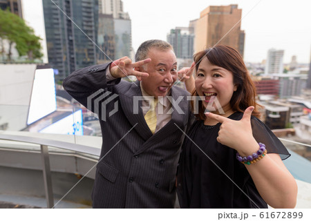 Mature Asian businessman and mature Asian woman exploring the city together Mature Asian businessman and mature Asian woman exploring the city together 61672899