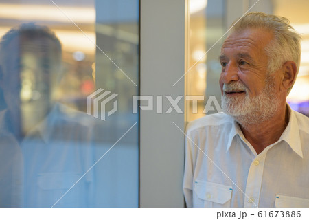 Handsome senior tourist man relaxing inside the mall 61673886