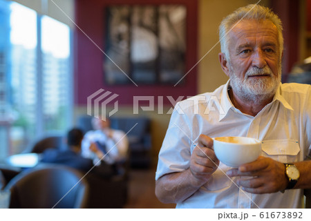 Handsome senior tourist man relaxing inside the coffee shop 61673892