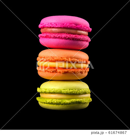 Stack of french colorful macaroons on wooden table isolated on black background Stack of french colorful macaroons on wooden table isolated on black background 61674867