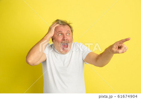 Caucasian senior man's portrait isolated on yellow studio background Caucasian senior man's portrait isolated on yellow studio background 61674904