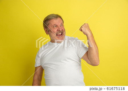 Caucasian senior man's portrait isolated on yellow studio background Caucasian senior man's portrait isolated on yellow studio background 61675118