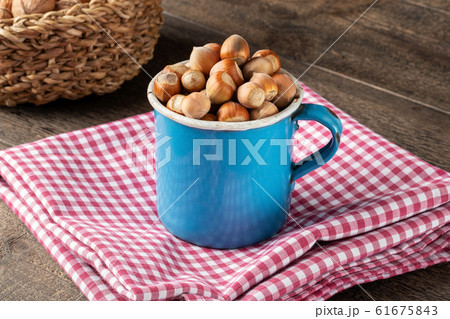 Hazelnuts in a blue vintage pot on a table 61675843
